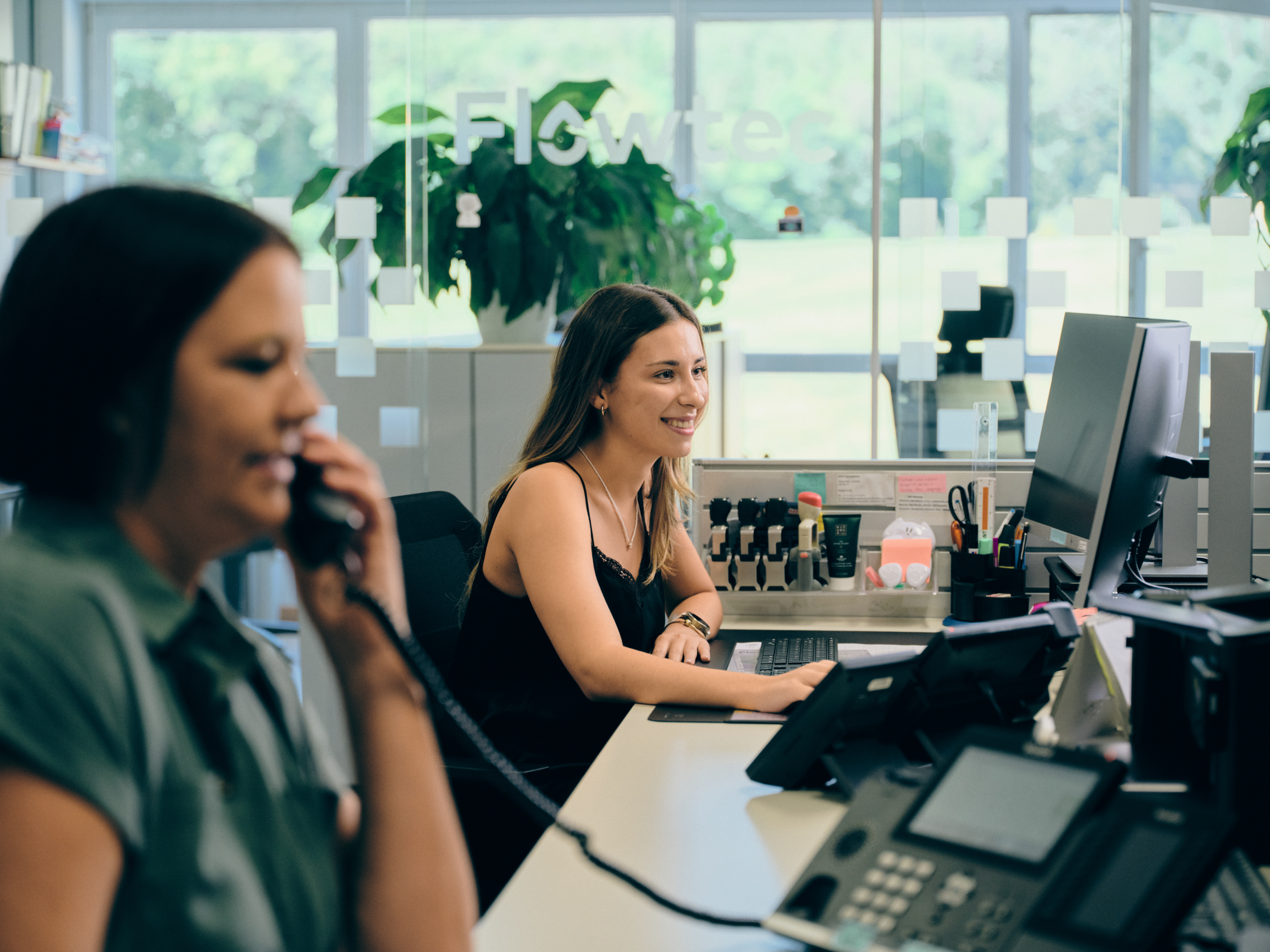Zwei Flowtec-Mitarbeiterinnen bei der Büroarbeit und Kundenberatung am Telefon